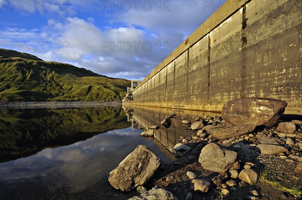 Hydro-electric dam and reservoir in Glen Lyon with pebbled shore and distant ridgeline, Glen Lyon,