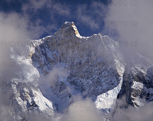 Afternoon mist and clouds gather around the dramatic peak of Jannu in the Kangchenjunga region of