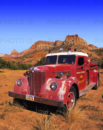 Old-style red fire engine parked on scrubland at the entrance to Zion Canyon, Utah, USA Oldtimer,