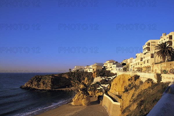 Apartments in early morning light under a deep blue sky overlook the deserted west end of the main