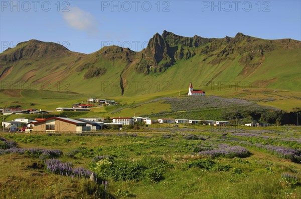 The town of Vik, southern Iceland, with its church above, all beneath crags and steep hillsides
