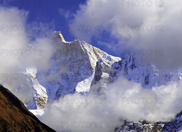 Afternoon mist and clouds gather around the dramatic peak of Jannu in the Kangchenjunga region of