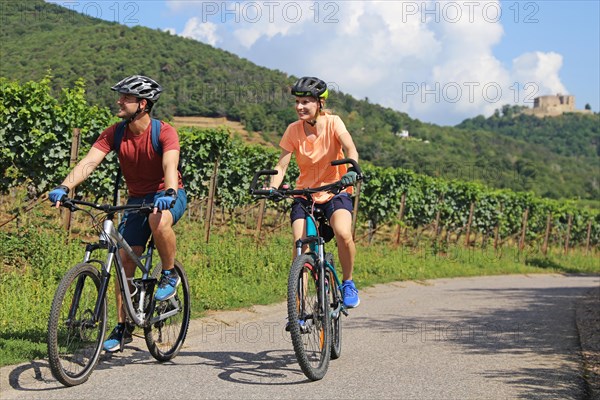 Symbolic image: Young couple on a cycle tour in the Palatinate near Maikammer. Vines and Hambach