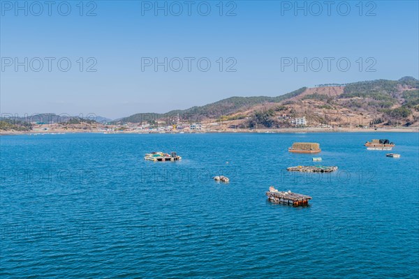Floating docks loaded with fishing gear in water off island coastal seaport in Yeosu, South Korea,
