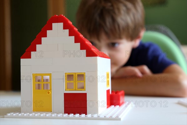 Symbolic image: Boy builds a house with building blocks