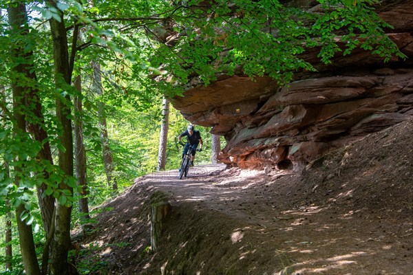 Mountain bikers on tour in the Dahner Felsenland . The many red sandstone rock formations
