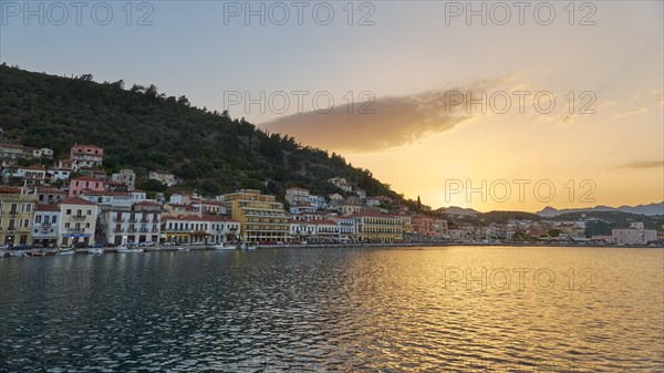 Town view at dusk with houses on the waterfront and mountains in the background, Taygetos