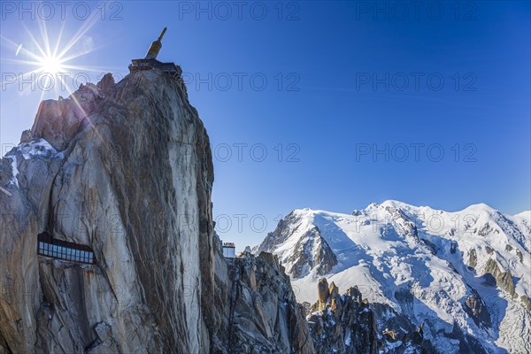 Mountain station and mountain peak with glacier in sunlight, backlight, fisheye, view of Aiguille
