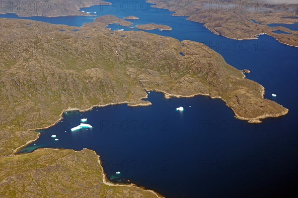 Iceberg, ice and islands, in a fjord, aerial view, rough, snow-covered rough mountain landscape,