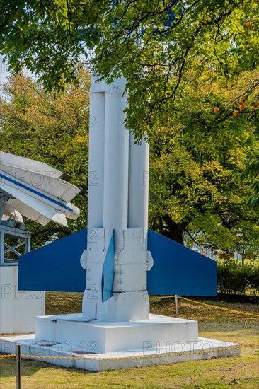 Lower portion of surface to air missiles behind tree branches in a public park