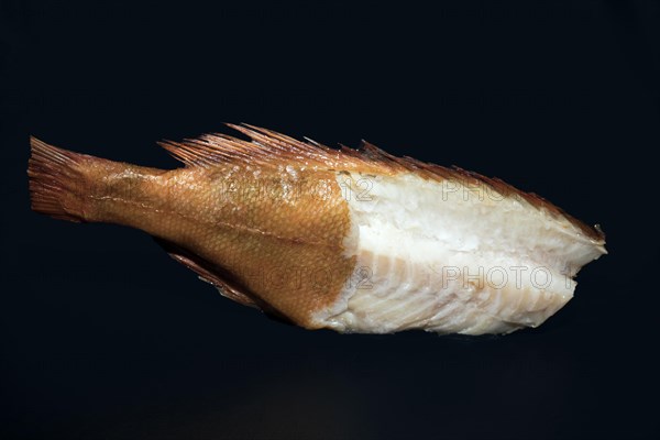 Smoked redfish without head, with half of the skin removed and part of the back fillet cut out,