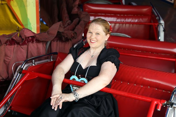 Cheerful woman travelling up and down the mountain at the Brezelfest in Speyer,