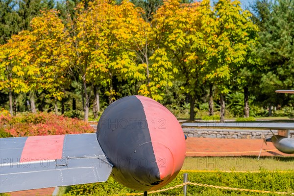 External fuel tank mounted on starboard wing of airplane on display in public park