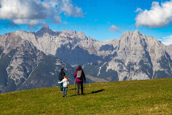 Hiking with children in Seefeld, Tyrol: Family hiking across an alpine meadow, with the Wetterstein