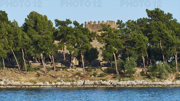 Old stone castle surrounded by pine trees on the Mediterranean coast, Gythio, Mani, Peloponnese,
