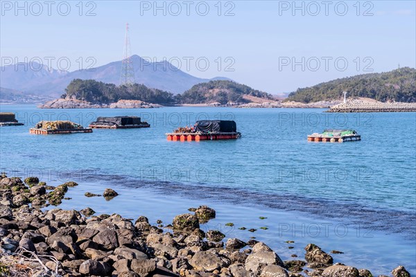 Floating docks loaded with fishing gear in water off island coastal seaport in Yeosu, South Korea,