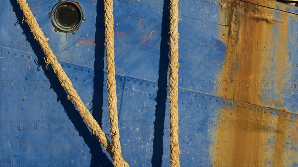 Detailed view of the side of a blue ship with ropes and rusty patches, Gythio, Mani, Peloponnese,