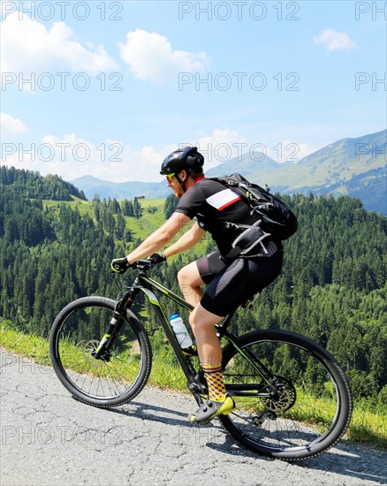 Mountain bikers in the Kitzbuehel Alps with alternating views of the Wilder Kaiser and the