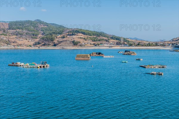 Floating docks loaded with fishing gear in water off island coastal seaport in Yeosu, South Korea,