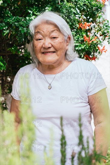 Portrait of a white-haired elderly woman of Japanese ethnicity smiling and looking at the camera in