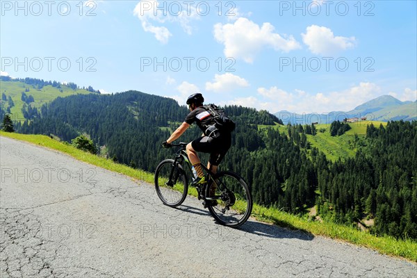 Mountain bikers in the Kitzbuehel Alps with alternating views of the Wilder Kaiser and the