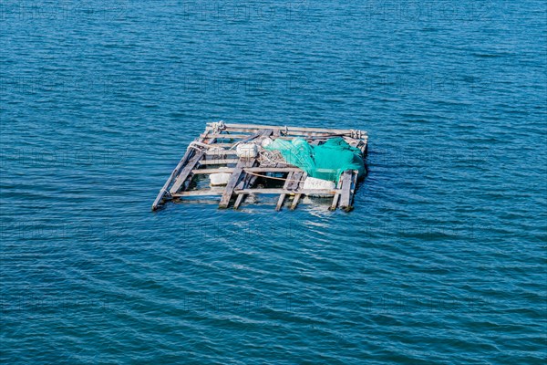 Dilapidated wooden raft held afloat with Styrofoam floats in ocean seaport in Yeosu, South Korea,