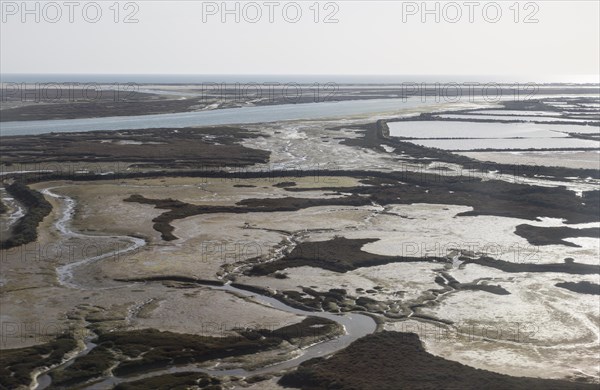 Coastal landscape of salt marsh and drainage channels along the coastline off Faro, Algarve,