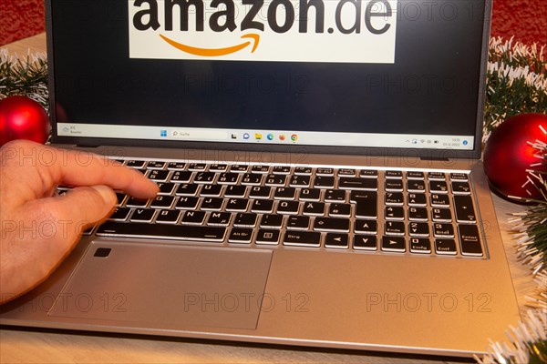 Symbolic image of Christmas shopping on the internet/at Amazon: Christmas decorations and laptop