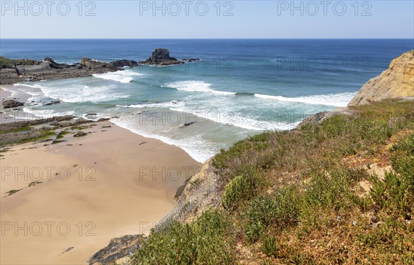 Sandy Carvalhal beach in bay between rocky headlands at Parque Natural do Sudoeste Alentejano e