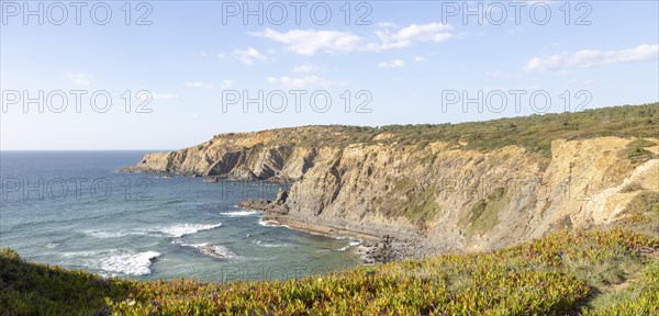 Rocky coastal landscape Praia dos Alteirinhos beach in bay with rocky headland part of Parque