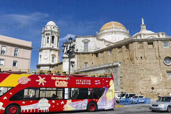 Red double-decker bus with tourists in front of the cathedral of Cadiz, Cathedral of the Holy Cross