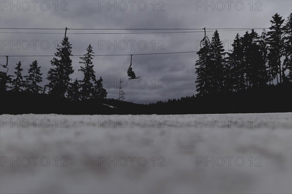 Skiers ride a chairlift, taken on a ski slope in the Jizera Mountains ski area near Albrechtice v