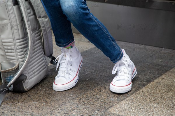Woman wears white chucks and jeans