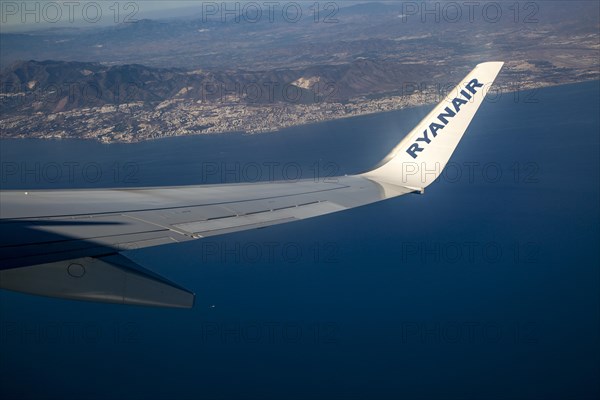Wing of Ryanair aircraft above Mediterranean Sea over the Costa del Sol taking off from Malaga,