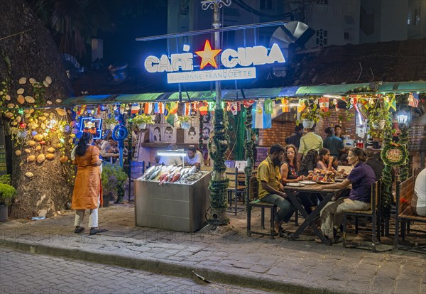 Diners enjoy a lively evening at a street-side restaurant on Tower Road, Fort Kochi, Cochin,