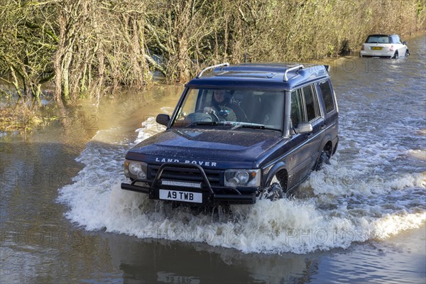 Land Rover Discovery Td5 vehicle driving through flood water at Kellaways, Wiltshire, England, UK
