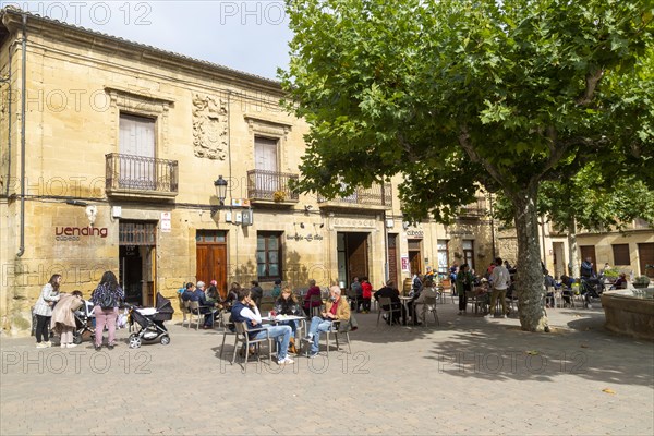 People sitting outside a cafe in Plaza Mayor, village of San Vicente de la Sonsierra, La Rioja,