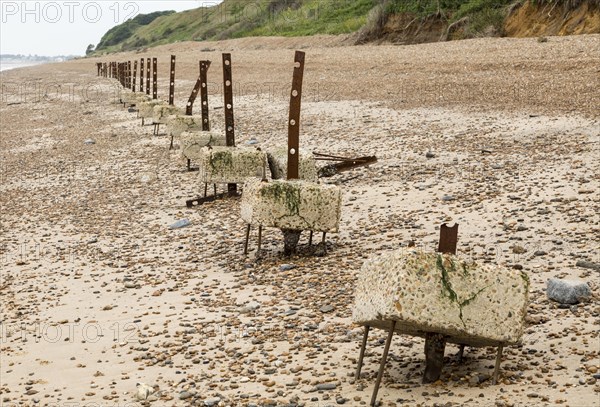 Remains of steel stanchions for barbed wire anti-invasion defences on beach at Bawdsey, Suffolk,
