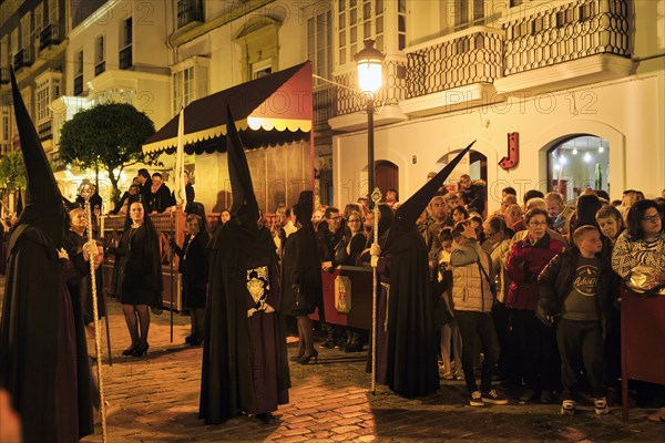 Nazarenos with black robes and typical pointed bonnets, insignia, Semana Santa, procession, night