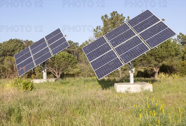 Solar panel array in rural location of field in countryside providing domestic energy near village