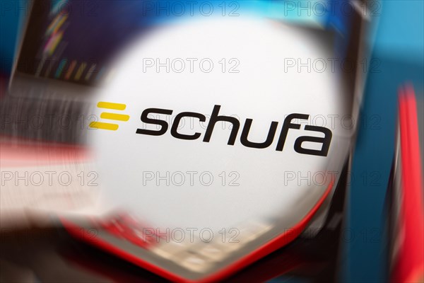 Symbolic image Schufa (information) : Schufa logo in front of a desk with tablet, calculator and