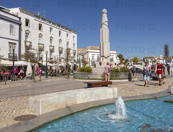 People sitting in sunshine outside street cafes in Praca da Republica, Tavira, Algarve, Portugal,