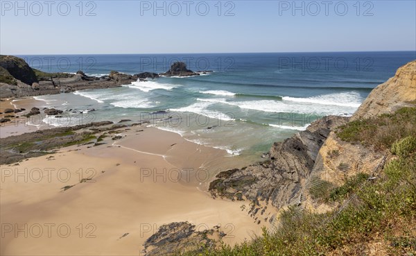 Sandy Carvalhal beach in bay between rocky headlands at Parque Natural do Sudoeste Alentejano e