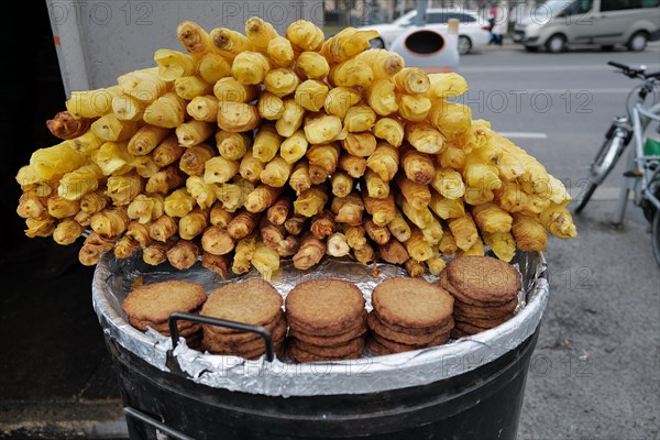 Reiberdatschi or fried potato pancakes beside fried potato slices at an outdoor stall on a cold