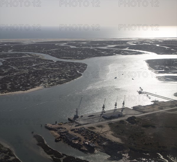 Coastal landscape of salt marsh and drainage channels along the coastline off Faro, Algarve,