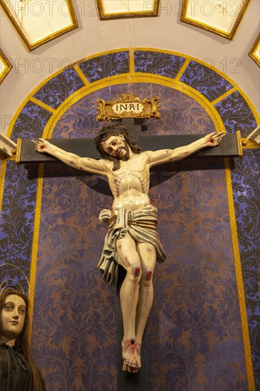 Ornately decorated Jesus Christ crucified on Cross church Igreja de Santiago, Tavira, Algarve,