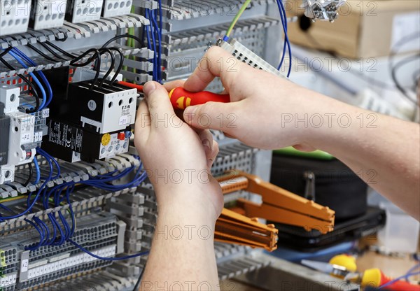 An electronics apprentice assembles a motor protection relay at a Deutsche Bahn training centre,