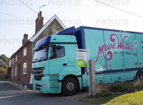 Removal van and estate agent sold sign next to house, moving in day, Shottisham, Suffolk, England,