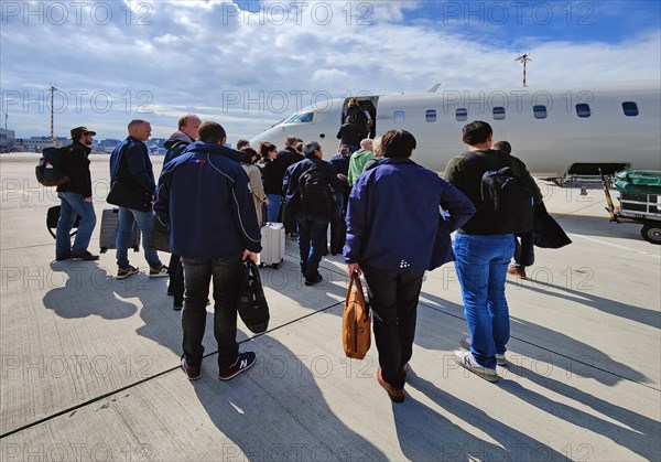 Passengers with hand luggage boarding a small aircraft on the tarmac, Duesseldorf Airport, North