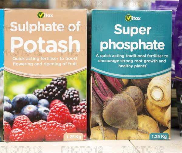 Cardboard boxes of Vitax Sulphate of Potash and Super Phosphate on shelf display in garden centre,
